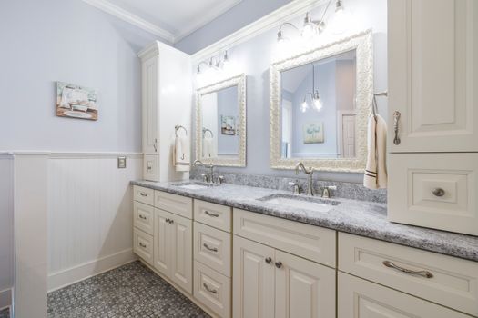 Spacious modern bathroom featuring dual sinks, large mirrors, and ample cabinet storage.