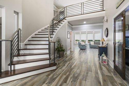 Free Spacious modern home interior featuring a curved staircase and stylish decor. Stock Photo