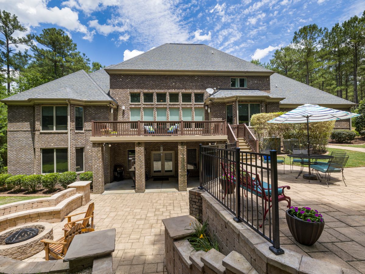 Premium paver patio with a fire pit and stone wall at a Southern home