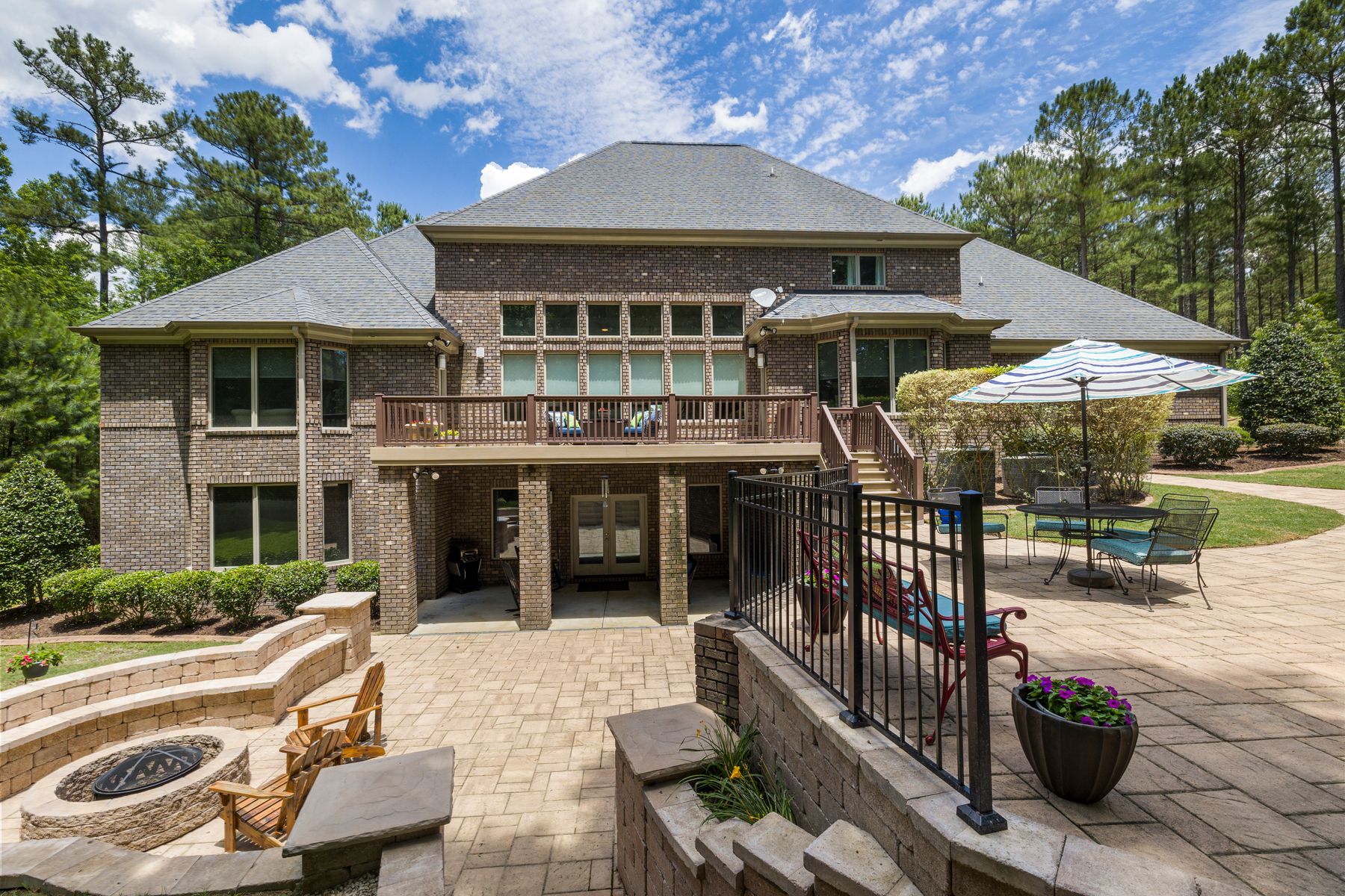 Large residential paver patio with a fire pit and seating