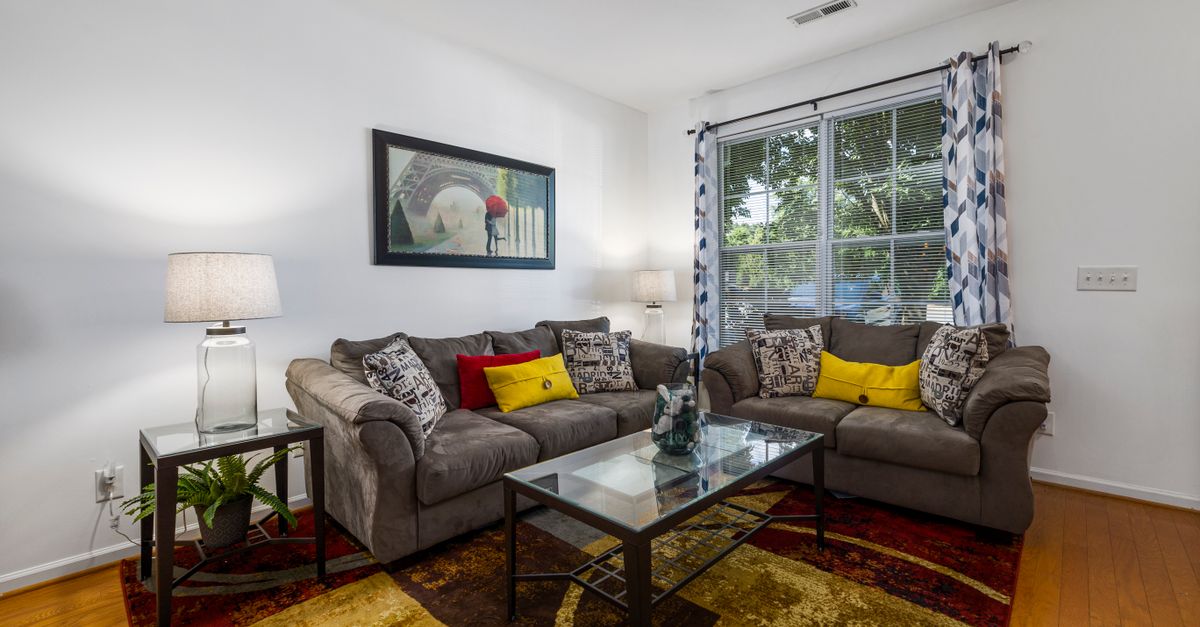Elegant living room interior featuring a glass coffee table, comfortable sofas, and stylish decor for a cozy ambiance.
