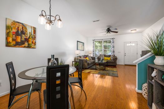 Bright modern living room with stylish decor and glass dining table.