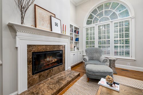 A Gray Sofa Chair and Ottoman Near Fireplace