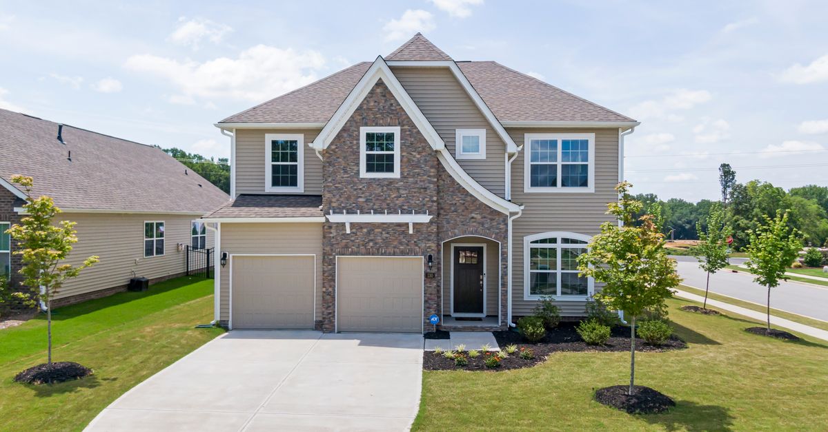 Charming modern family home with a brick facade, landscaped yard, and double garage in Garner, NC.
