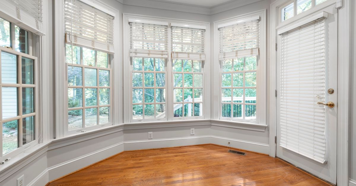 Bright interior space with large windows and wooden floors, perfect for home decor or real estate.