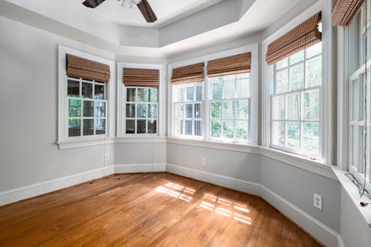 Spacious room with bay windows and wooden floor, perfect for home design inspiration.