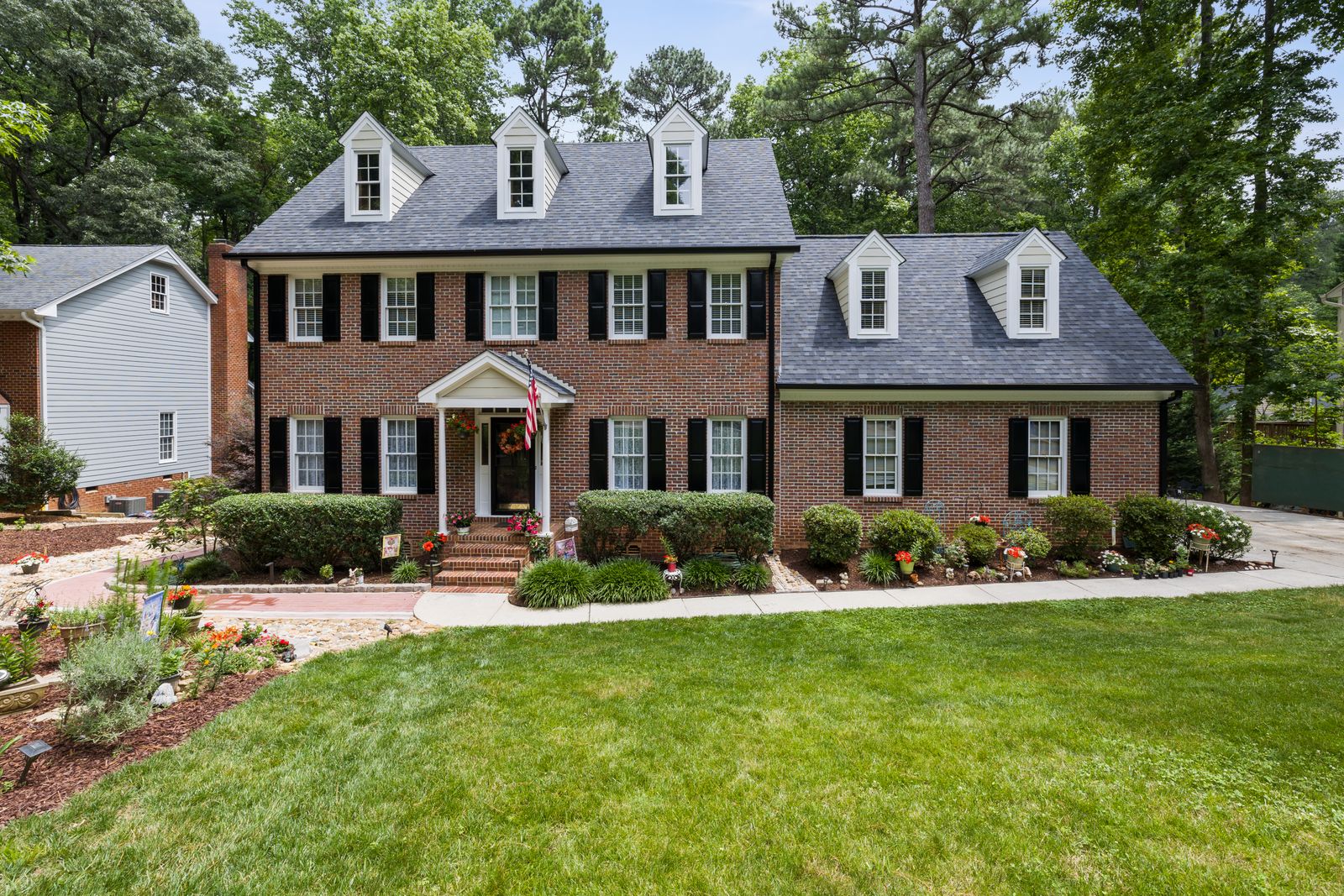 Two-story red brick Colonial Revival home with black shutters and dormers, Saybrook, Naperville IL