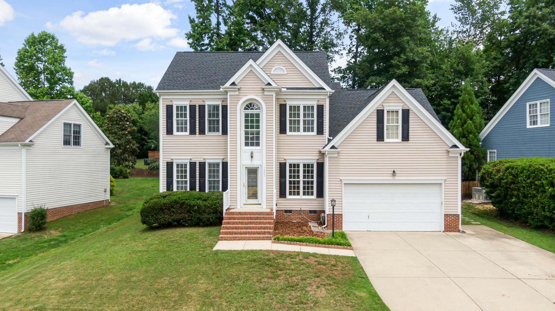 A beautiful two-story suburban home with a lush green lawn in Apex, NC.