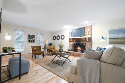Free Warm and inviting living room featuring a brick fireplace and elegant decor. Stock Photo