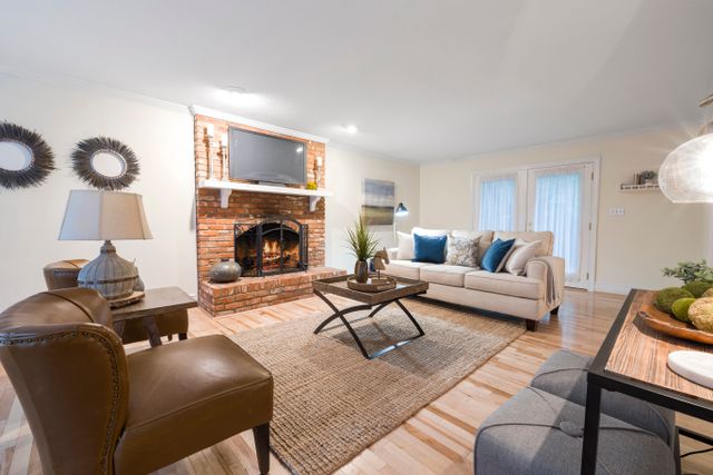 Living room with a brick fireplace and built-in shelving — photo by Curtis Adams on Pexels