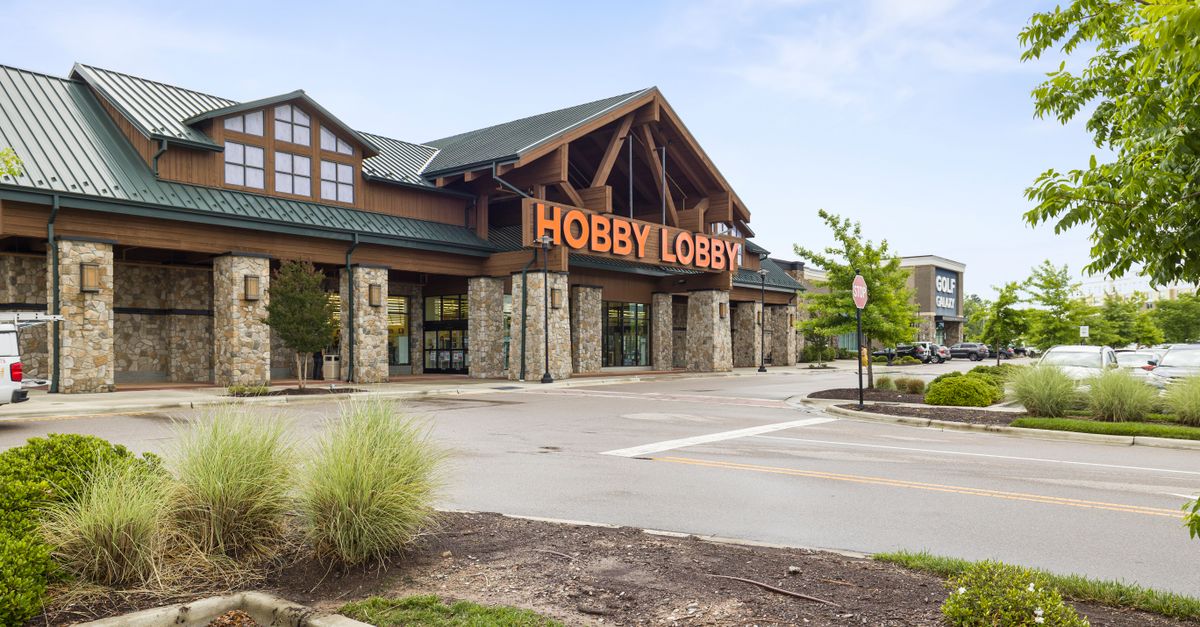 Front view of a Hobby Lobby store with clear blue sky and parking area.