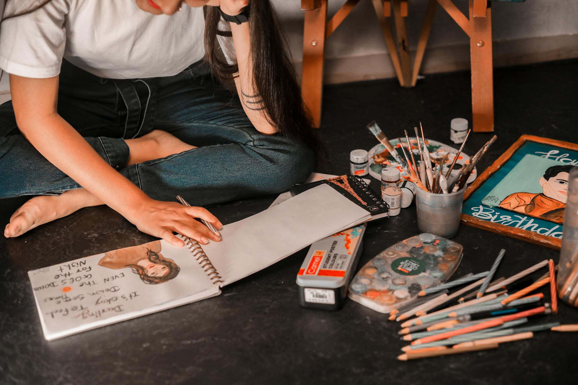 A young woman artist in Surat crafting beautiful paintings and sketches using various art supplies.