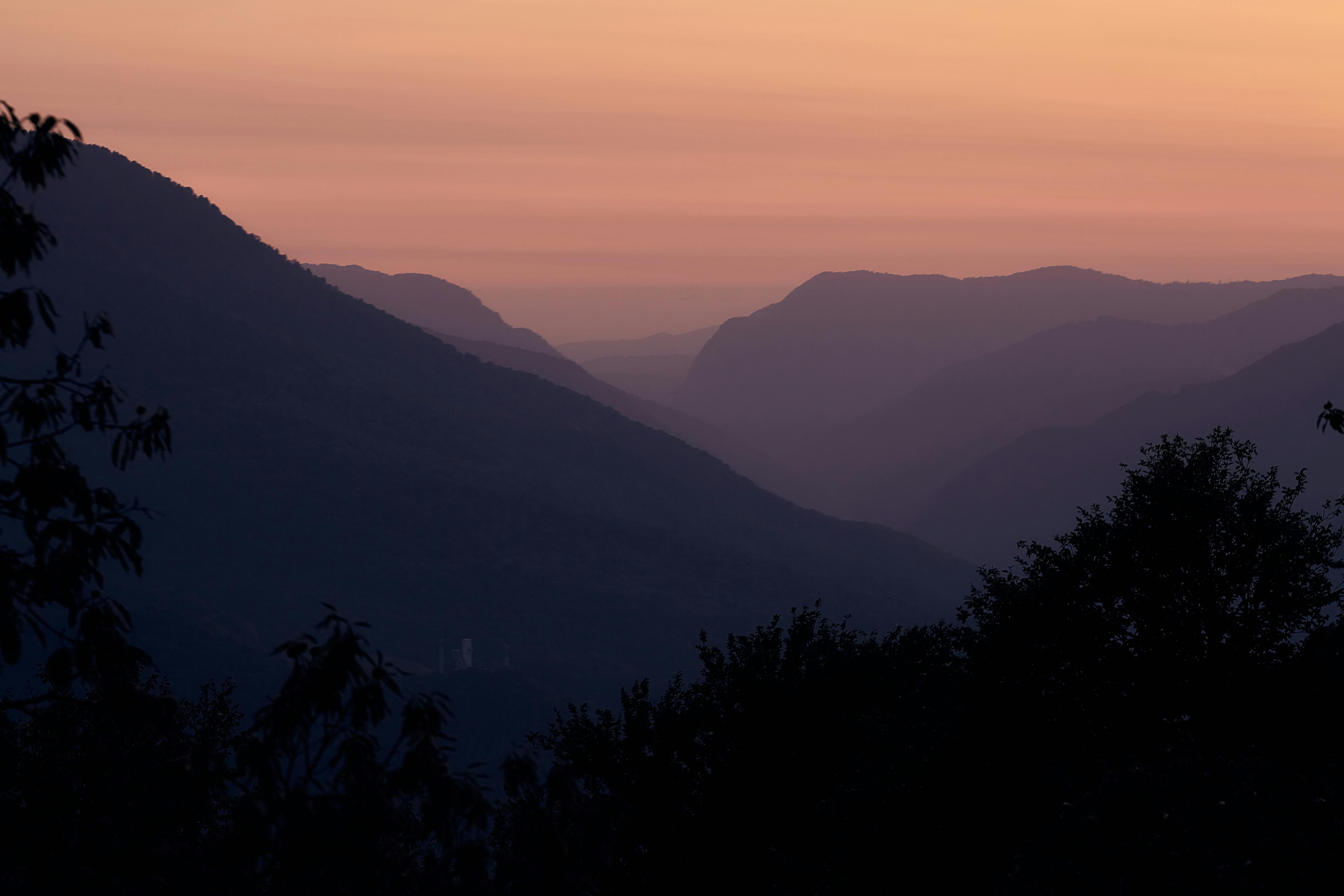 A beautiful silhouette of mountains under a twilight sky, evoking peace and tranquility.