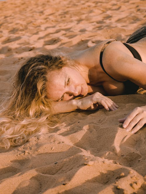 Woman in Black Bathing Suit Lying on Sand
