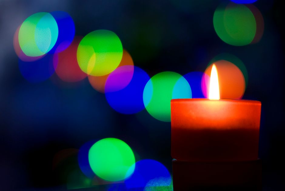 Red candle lit, blurred circles of colour in the background abstract, blur, bokeh