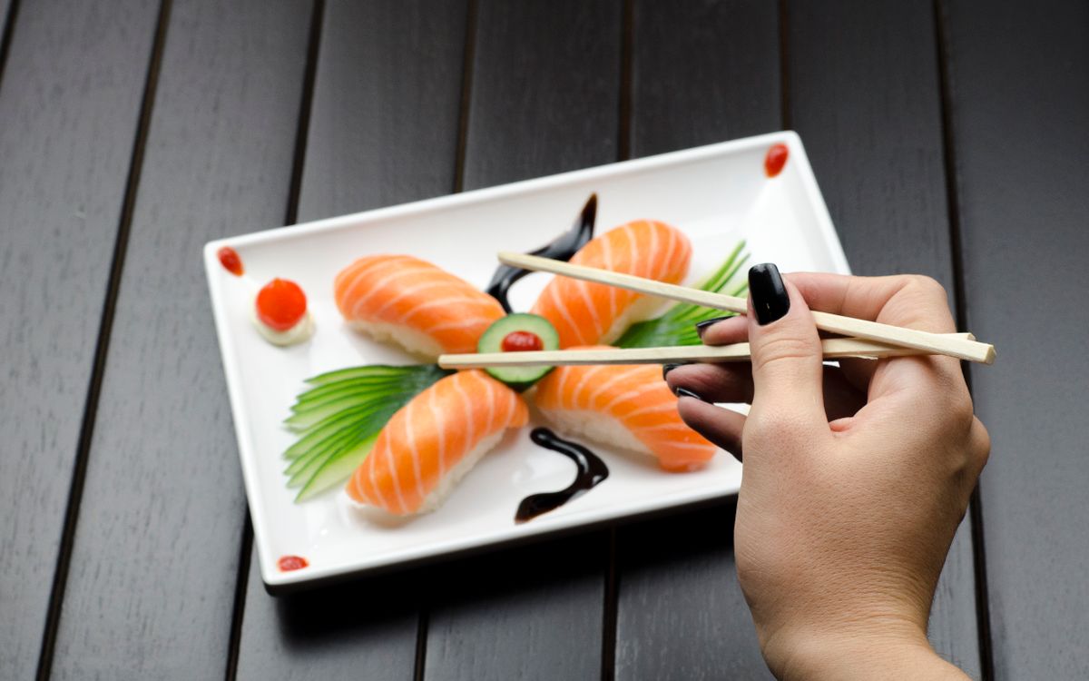 Ordering sushi with chopsticks at a Japanese restaurant
