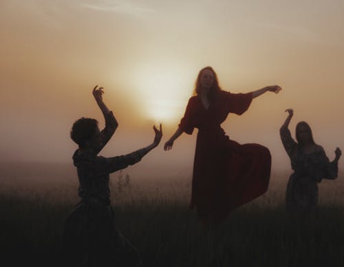 Free A Group of Women Dancing on Grass Field Stock Photo