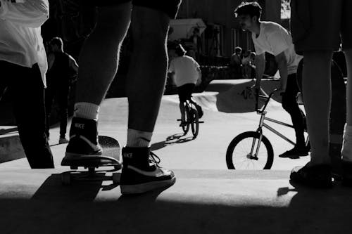 Black and White Photo of People in the Street Riding a Bicycle