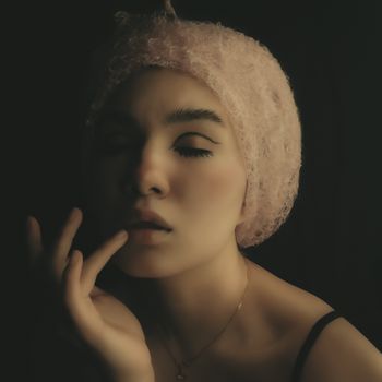 A captivating artistic portrait of a young woman with closed eyes and soft lighting.