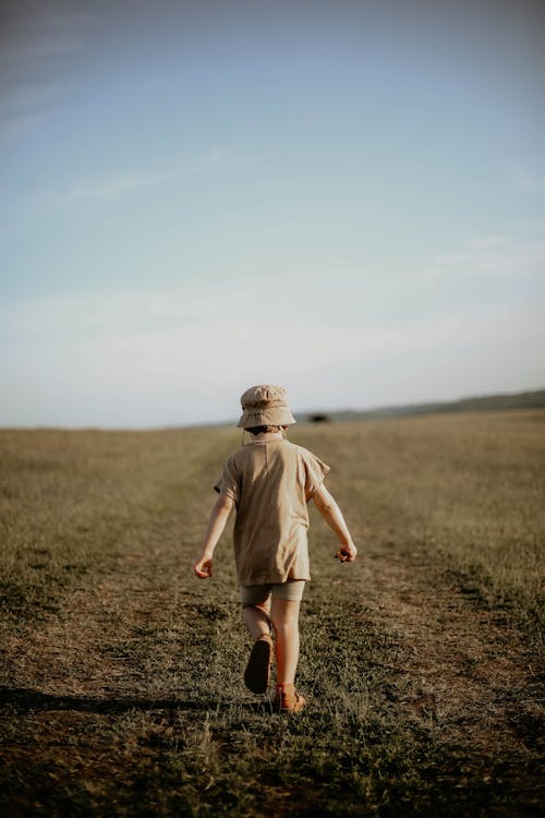 Back View of a Young Boy Walking on the Grass