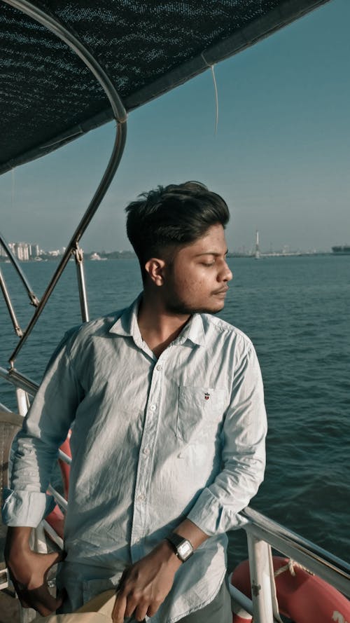 Man in Blue Shirt Standing in the Boat