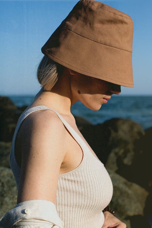 Side Profile of a Woman Wearing White Top and Brown Bucket Hat