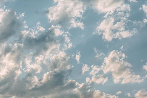Free Captivating view of soft clouds scattered across a clear blue sky, evoking tranquility. Stock Photo