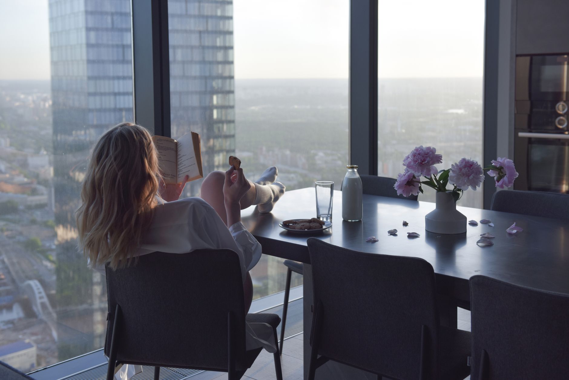 A woman reads by a window in a room arranged around her own routines, the private ease that can make old dating scripts feel suddenly flimsy.