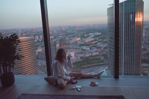 Free Woman Sitting on the Floor Beside a Window Stock Photo