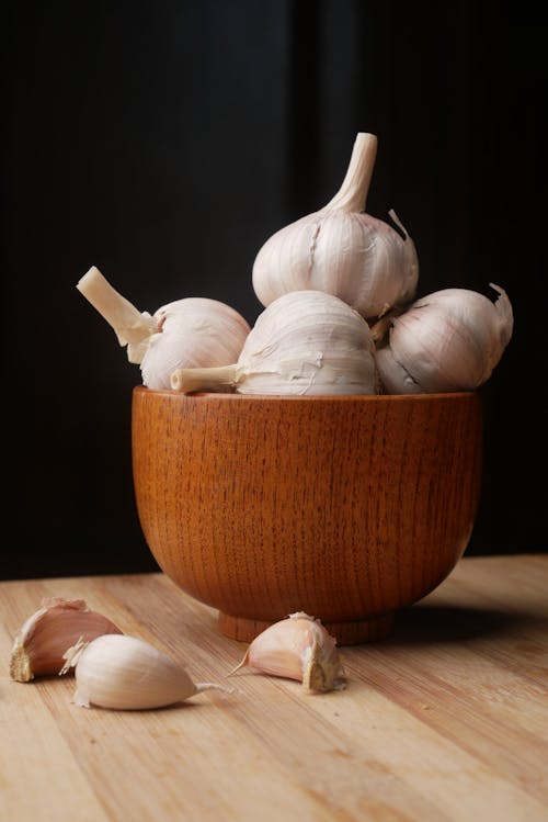 Bulbs of Garlics in Brown Wooden Mortar