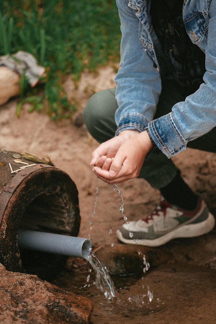 Washing Hands With Water Running From A Pipe 