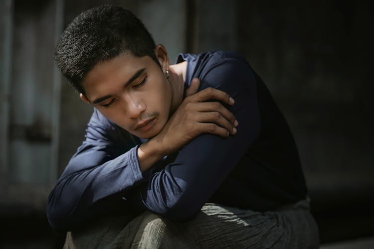 A Young Man Resting Chin On His Hand With Eyes Closed