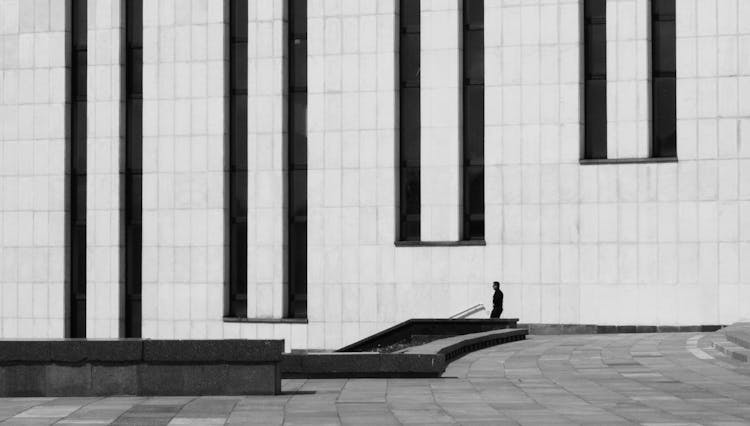 Man Walking Stairs Near Geometrical Modern Building