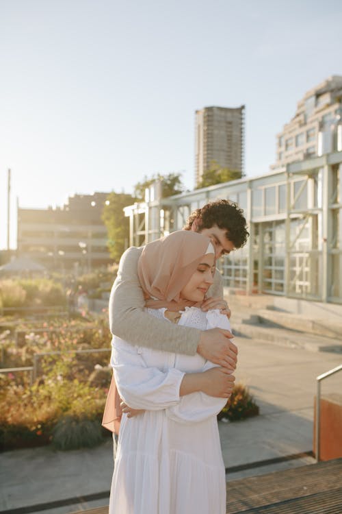 Free Couple Embracing in a Morning Light in a City Stock Photo