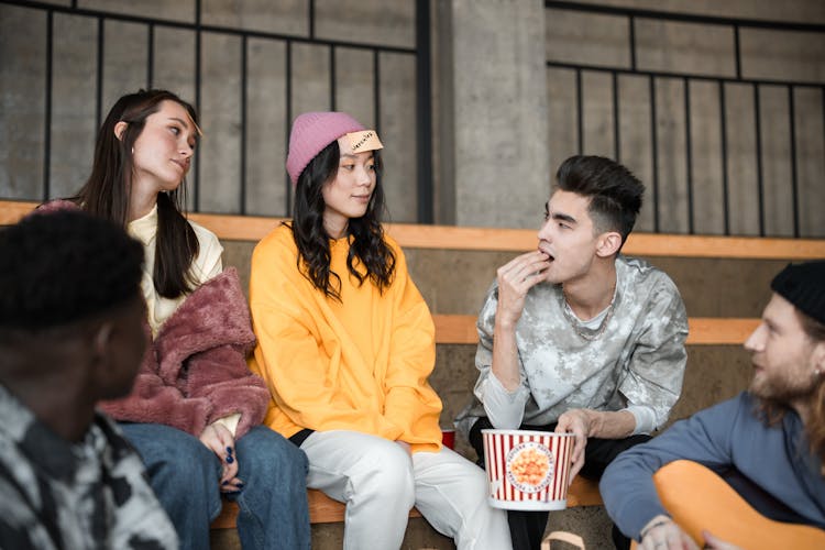 Friends Sitting And Eating Popcorn