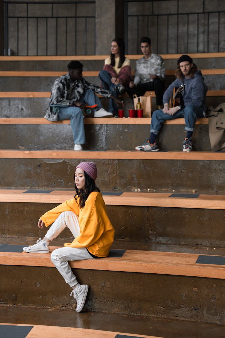 Stylish Young People Sitting On Concrete Bleachers 