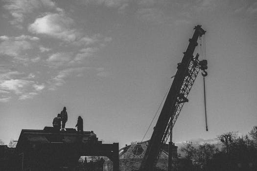 Silhouette of workers with crane on a construction site in Moscow, Russia.