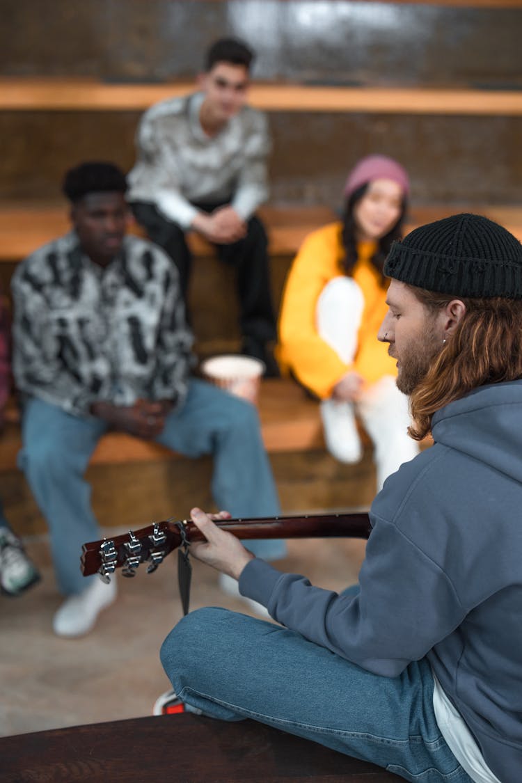 Man In Blue Hoodie Playing A Guitar 