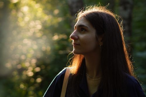 Free Profile of a woman in a sunlit forest, exuding tranquility and natural beauty. Stock Photo