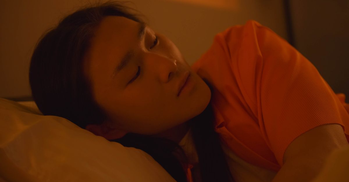person sleeping peacefully with a sunrise in the background, symbolizing rest and productivity