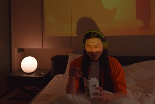 A Man Eating on a Bed 