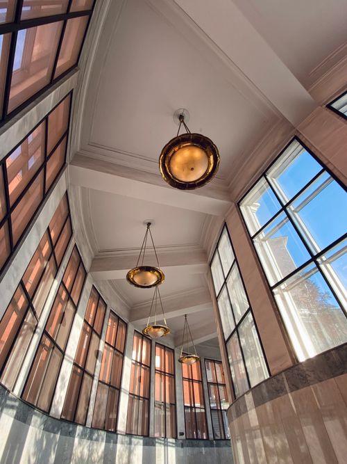 Free Stylish interior with large windows, ceiling lights, and architectural detail in a curved corridor. Stock Photo