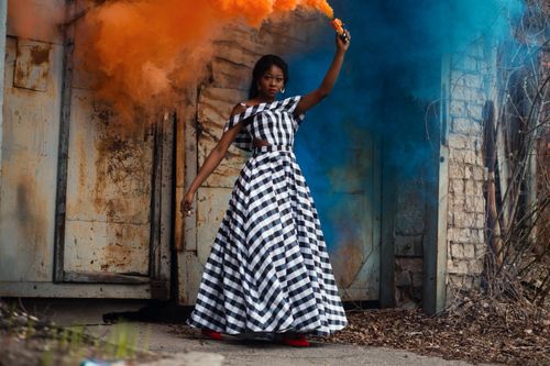 Free Fashion model posing with vibrant smoke bombs in an urban setting. Stock Photo