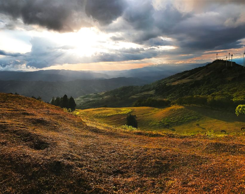 Stunning sunset landscape in San José, Costa Rica, with rolling hills and dramatic clouds.
