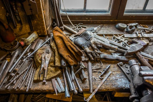 Tools and Protective Gloves on a Table in a Workshop 