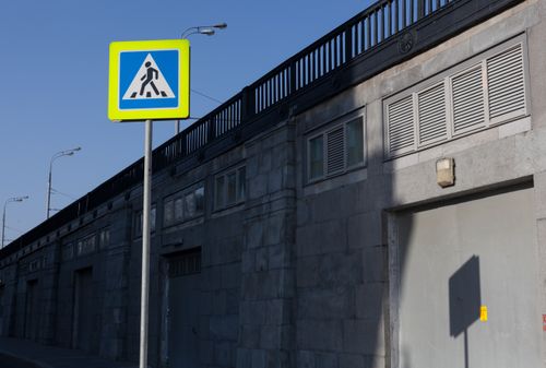 Free Modern urban scene in Moscow featuring a pedestrian crossing sign and shadows on a building. Stock Photo