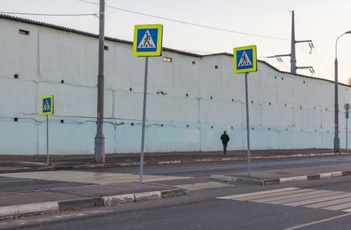 Free Street view in Moscow with pedestrian sign and person walking along a wall. Stock Photo