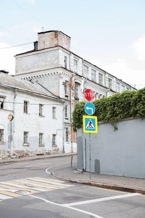 Free An urban scene with aged buildings showcasing a stop sign and pedestrian crossing, creating a historic city vibe. Stock Photo