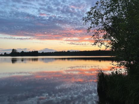 Experience the serene beauty of Valday Lake during a vivid summer sunset.