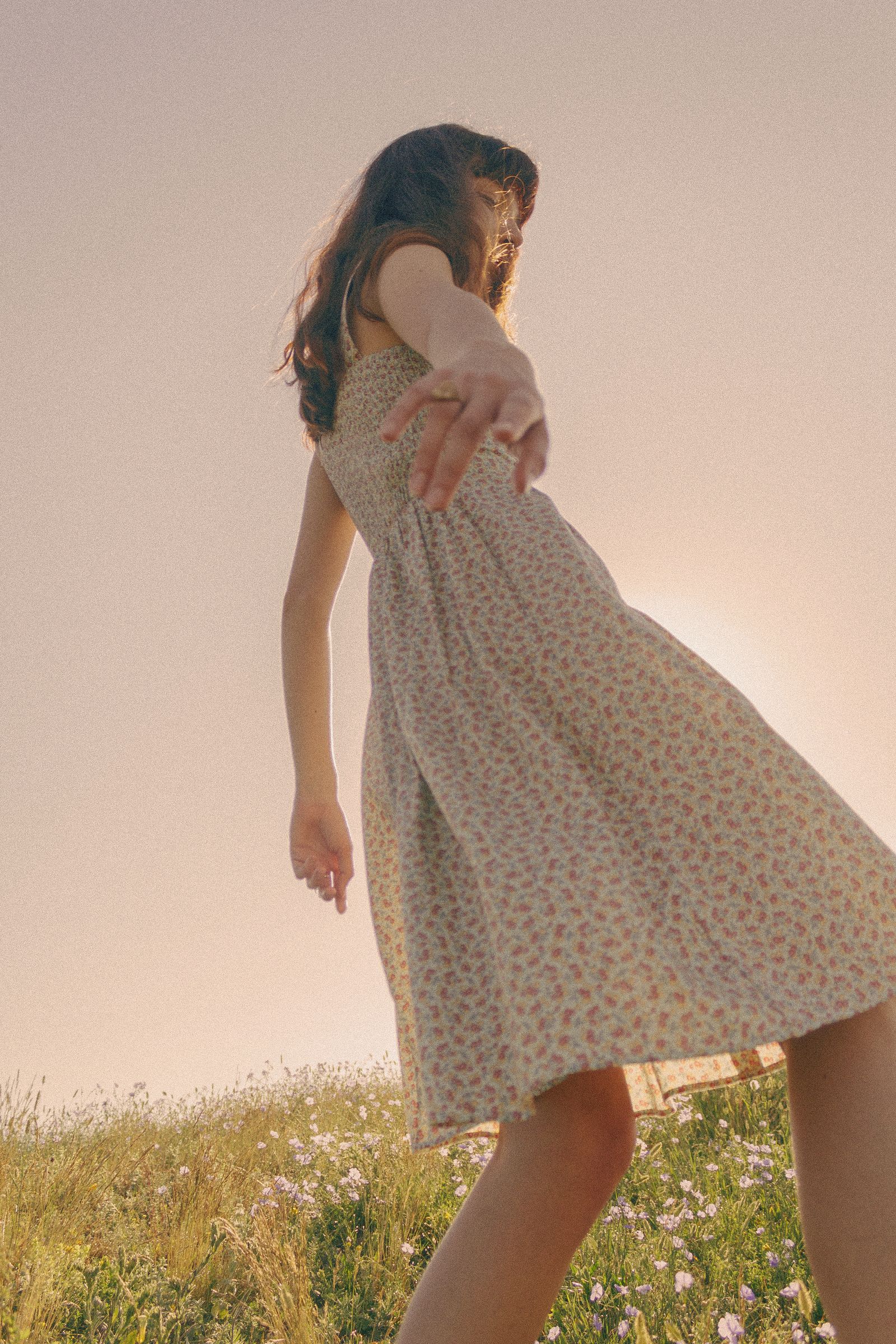 A woman in a flowing romantic dress, low angle